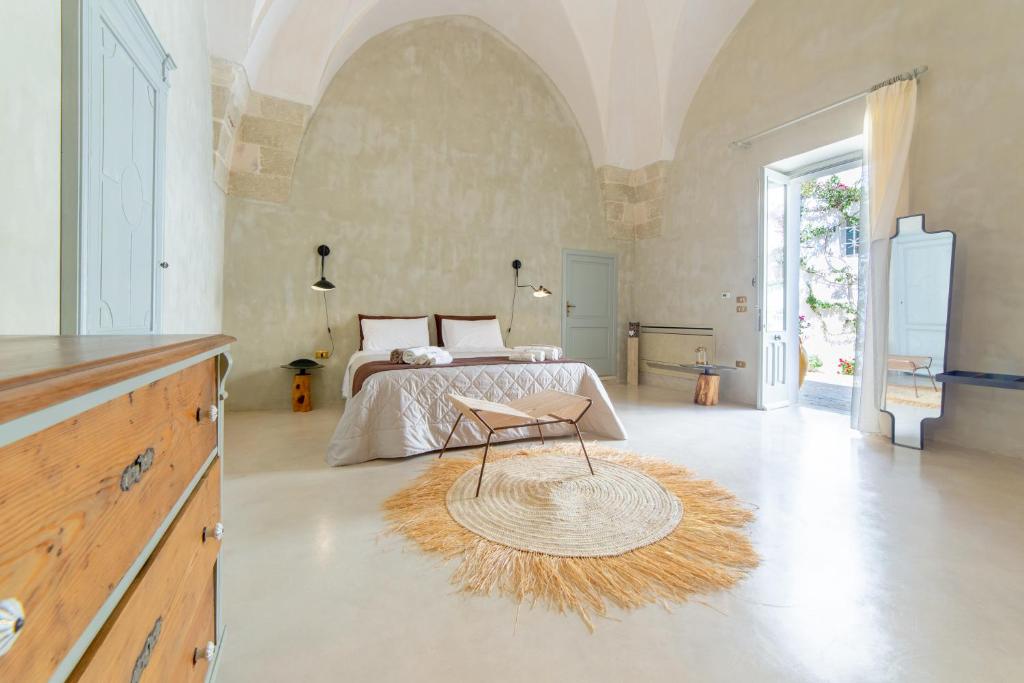 a bedroom with a bed and a table in it at Palazzo Angelica - Luxury Retreat Otranto in Giurdignano
