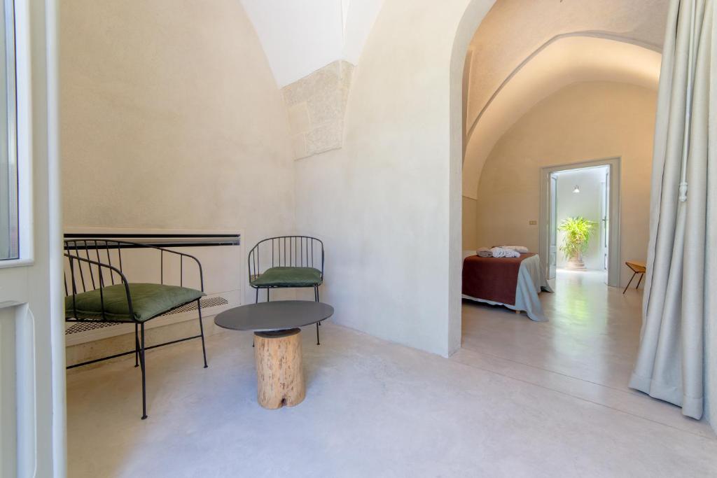 a room with a table and two chairs and a table at Palazzo Angelica - Luxury Retreat Otranto in Giurdignano