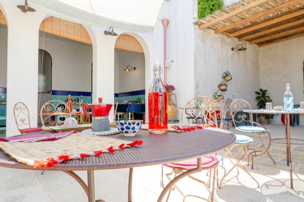 a table with chairs and a bottle on top of it at Palazzo Angelica - Luxury Retreat Otranto in Giurdignano