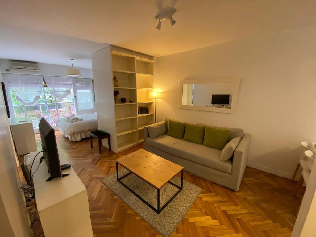 a living room with a couch and a tv at Cozy Studio in the heart of Recoleta in Buenos Aires