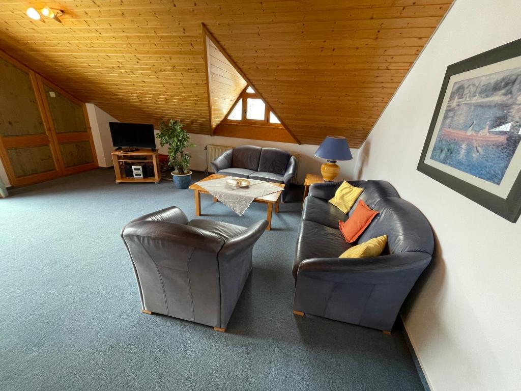 a living room with two leather chairs and a table at Ferienwohnung Victoria mit schöner Aussicht - Mein Schwarzwaldhäusle in Todtmoos