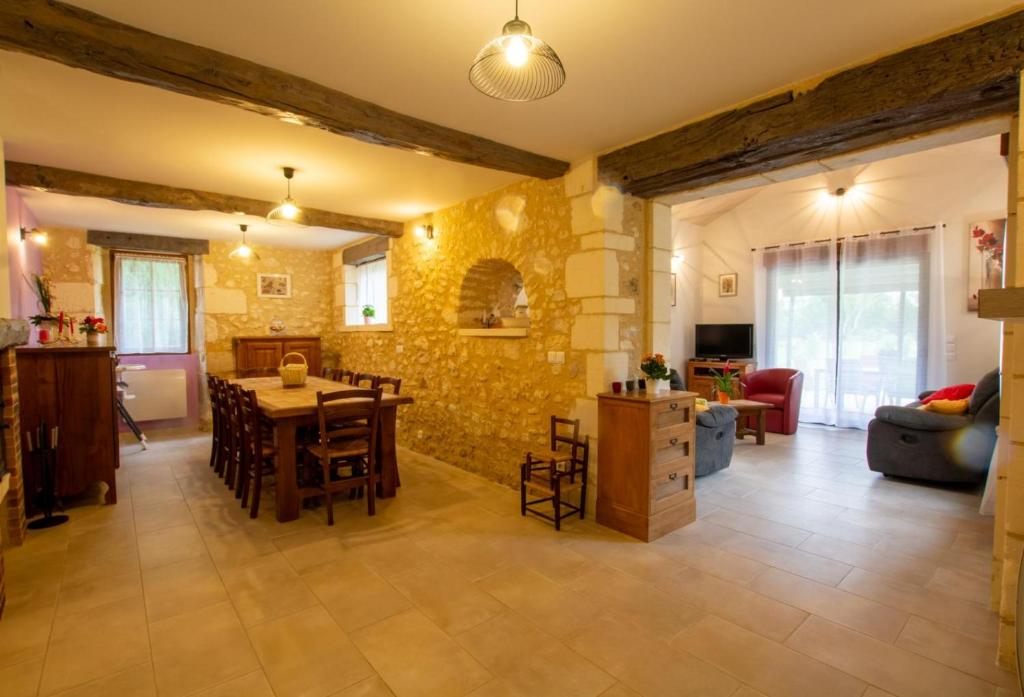 a large living room with a table and chairs at Moulin neuf de combecave pour 4 in Saint-Amand-de-Vergt