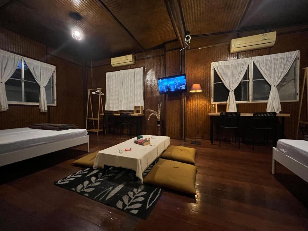 a room with two beds and a table in it at Once in Lampang Guesthouse in Lampang