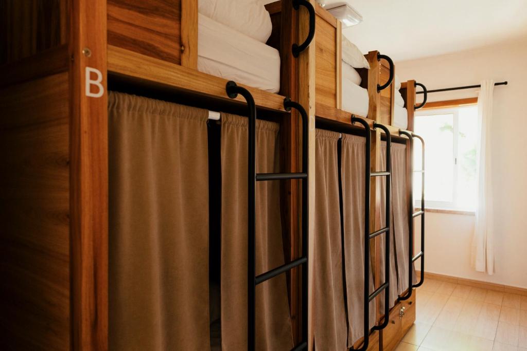 a row of bunk beds in a room at Lisbon Surf Hostel in Carcavelos