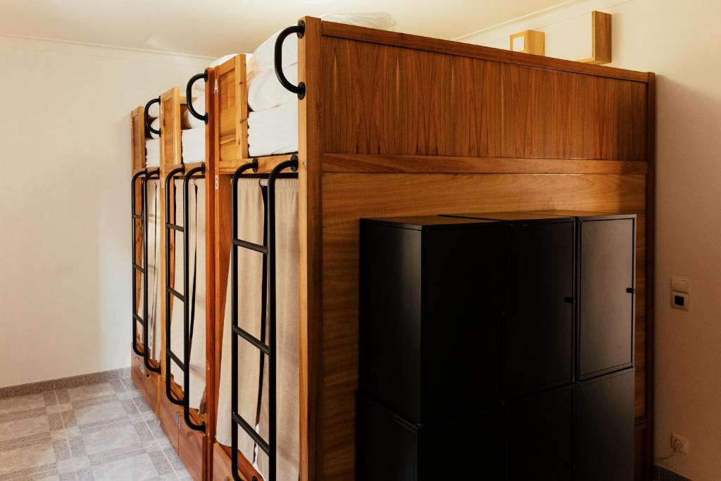 a row of bunk beds in a room with a refrigerator at Lisbon Surf Hostel in Carcavelos