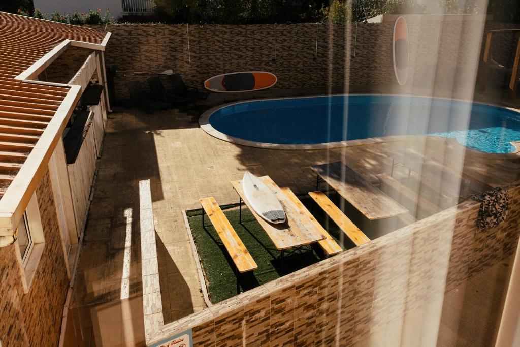 an overhead view of a swimming pool with a table and chairs at Lisbon Surf Hostel in Carcavelos