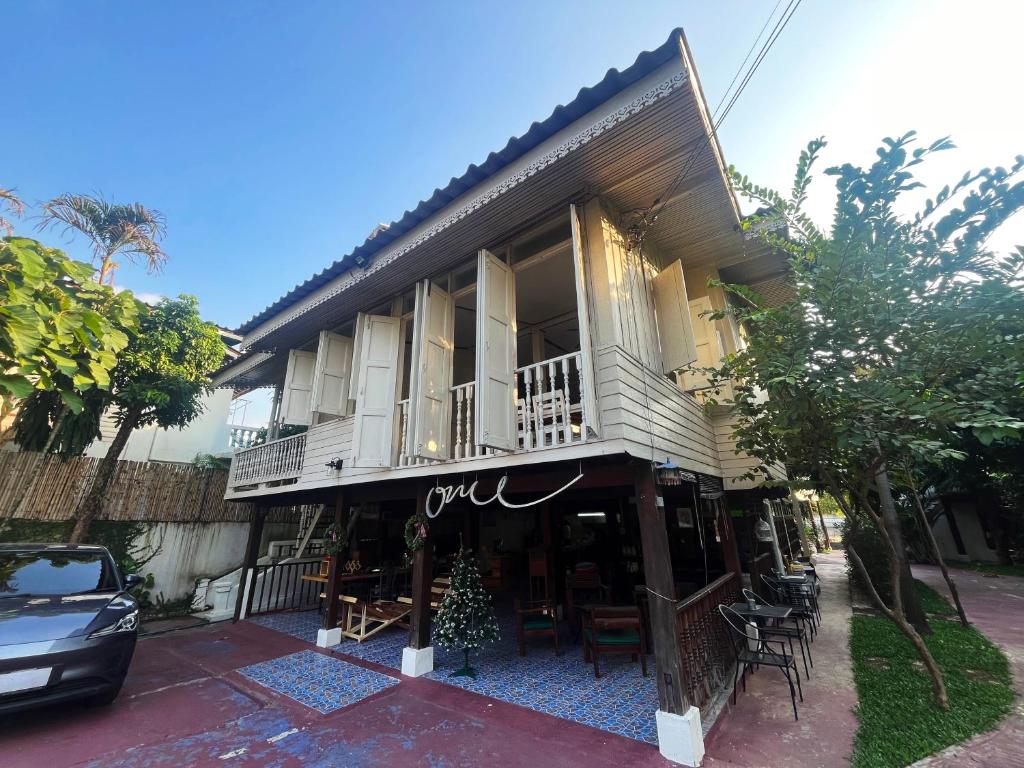 a building with a balcony and a restaurant at Once in Lampang Guesthouse in Lampang