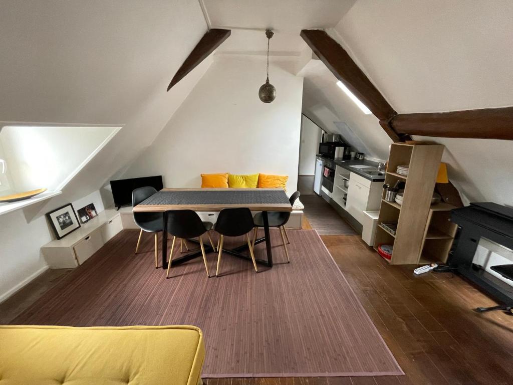 une salle à manger avec une table et quelques chaises dans l'établissement Appartement Atypique, centre de Paris, à Paris