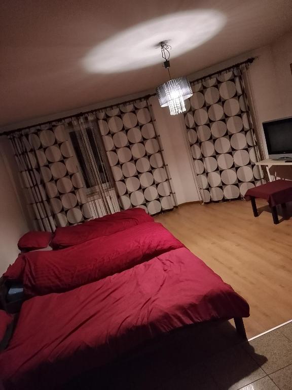 a bedroom with a red bed with a large headboard at Pokoje Lublin in Turka