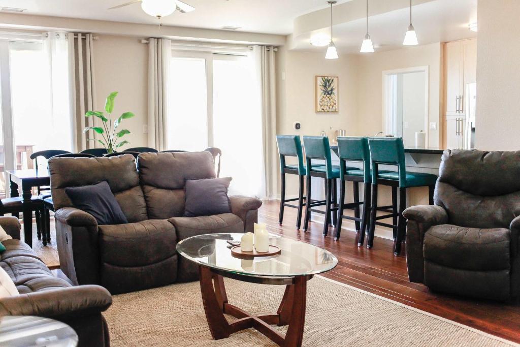 a living room with couches and a table and chairs at Sojourn's Sanctuary Condo Vitamin Sea Sleeps 6 in Virginia Beach