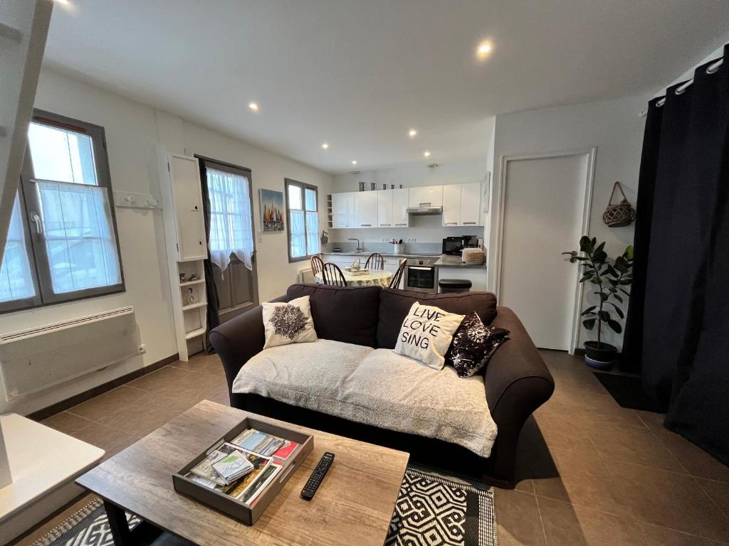 a living room with a couch and a table at Villa des Avocettes in Le Crotoy
