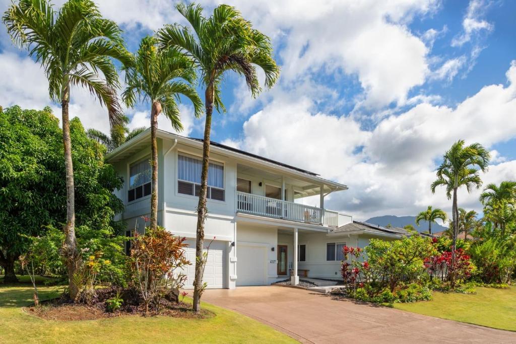 a house with palm trees in front of it at Hihimanu House in Princeville