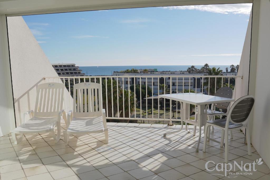 un balcon avec une table et des chaises et une vue sur l'océan dans l'établissement CapNat - Village Naturiste - Heliopolis - Appartement 2 pieces - Le Mont Olympe, au Cap d'Agde