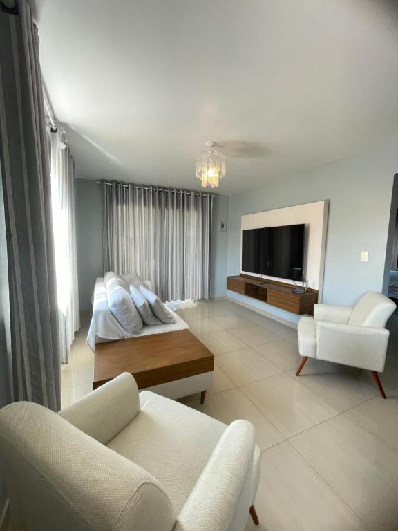 Una gran sala de estar con un sofá y un televisor. en Casa no centro de Porto Belo, en Porto Belo