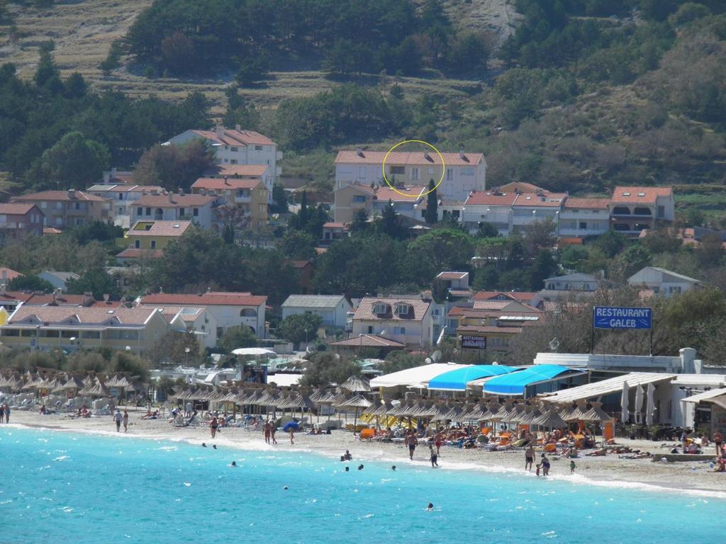 a group of people on a beach near the water at Apartments Limun Zarok in Baška