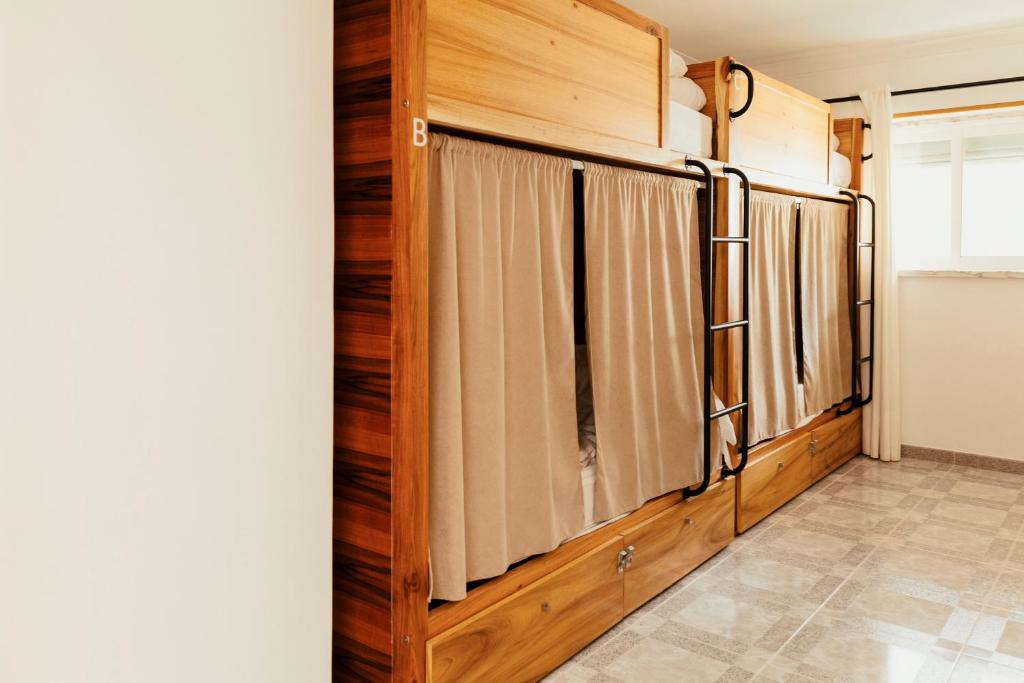 a hallway with wooden walls and curtains at Lisbon Surf Hostel in Carcavelos
