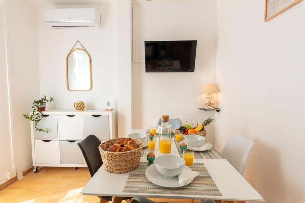 - une salle à manger avec une table, de la nourriture et du jus d'orange dans l'établissement La Maison de Papou, charmante maison de village avec vue mer idéalement située à la Madrague, à Hyères