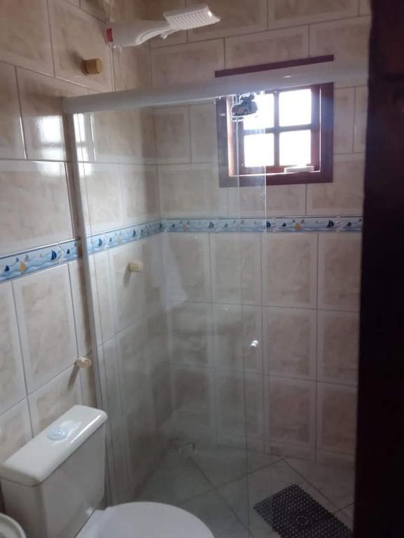 ein Badezimmer mit Dusche und Toilette und einem Fenster in der Unterkunft CasaBuzios in Búzios