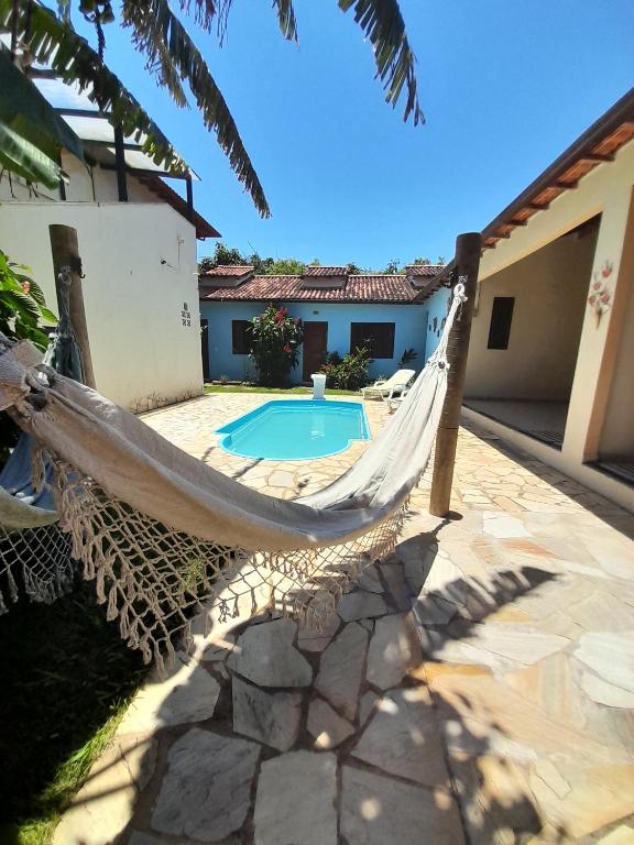 Eine Hängematte vor einem Haus mit Pool in der Unterkunft Le Marchand de Sable- Suites e apartamento in Búzios