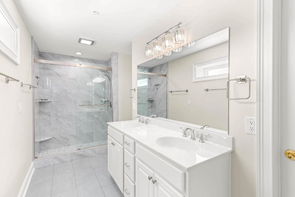 a white bathroom with a sink and a shower at Beach House 415 in Tybee Island