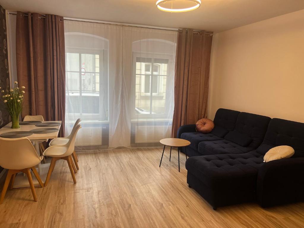 uma sala de estar com um sofá preto e uma mesa em Apartament na Grodowej koło Rynku em Gliwice