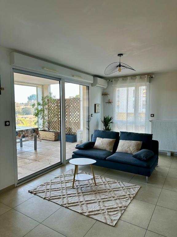 un salon avec un canapé bleu et une table dans l'établissement Très bel appartement - 2 chambres, à Montpellier