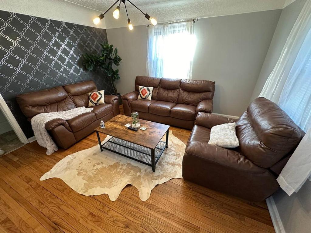 a living room with a leather couch and a coffee table at 3 Bedroom Fenced Backyard Pets Welcome Sleeps 6 in Lincoln Park