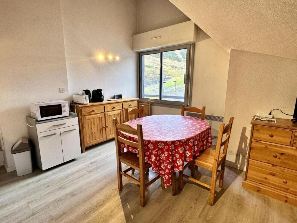 une cuisine avec une table et des chaises et un micro-ondes dans l'établissement Résidence Face Sud - maeva Home - Studio 5 personnes - Confort MAE-1881, à La Mongie