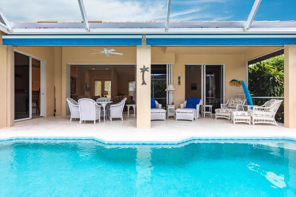 a house with a swimming pool and a patio at Marco Home - 3BR - Pet Friendly - Pool & Lanai in Marco Island