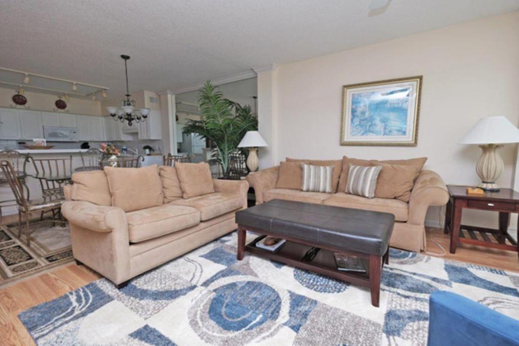 a living room with two couches and a table at Whitney Parish Retreat Beachfront Bliss in Pawleys Island
