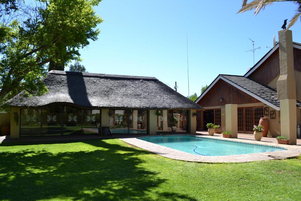 a house with a swimming pool in the yard at Castello Guesthouse Vryburg in Vryburg