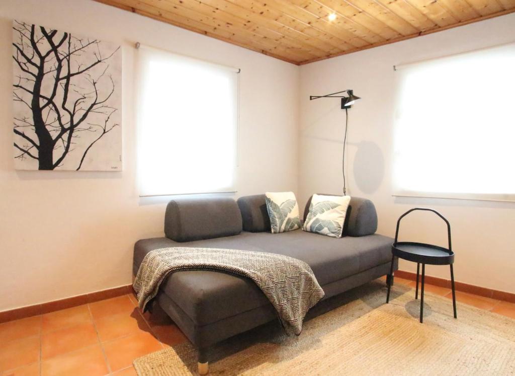 - un canapé dans le salon avec 2 fenêtres dans l'établissement Casa do Farol - Charming Townhouse, à Lagos