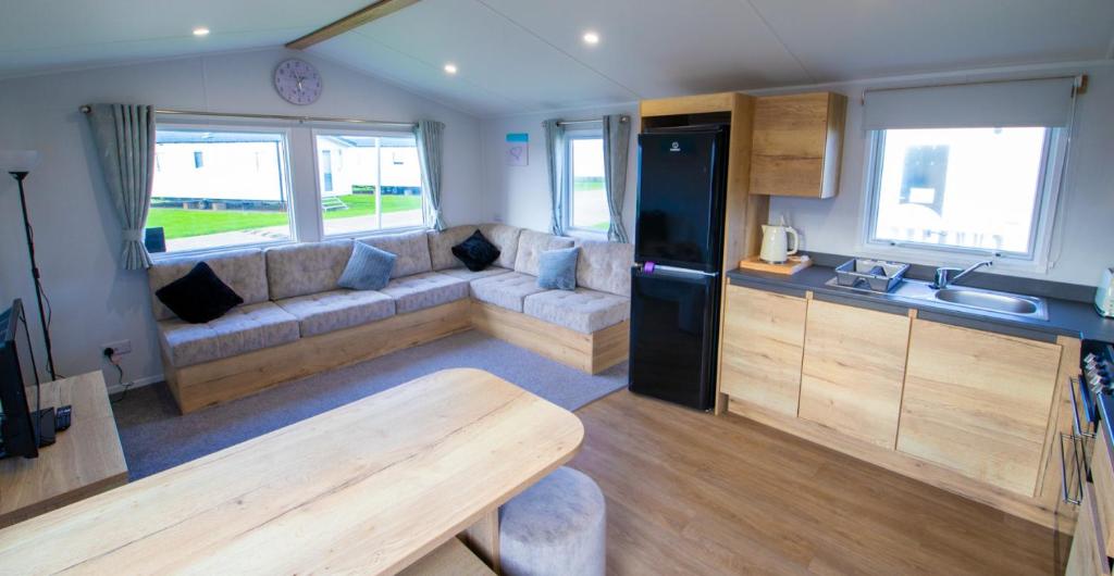 a living room with a couch and a table in a caravan at MP303 Parkdean Camber Sands in Camber