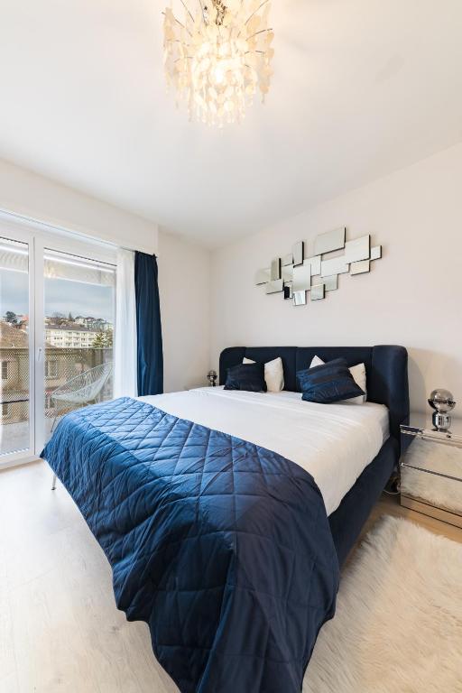a bedroom with a large bed and a chandelier at Swiss Flat Rental in Lausanne