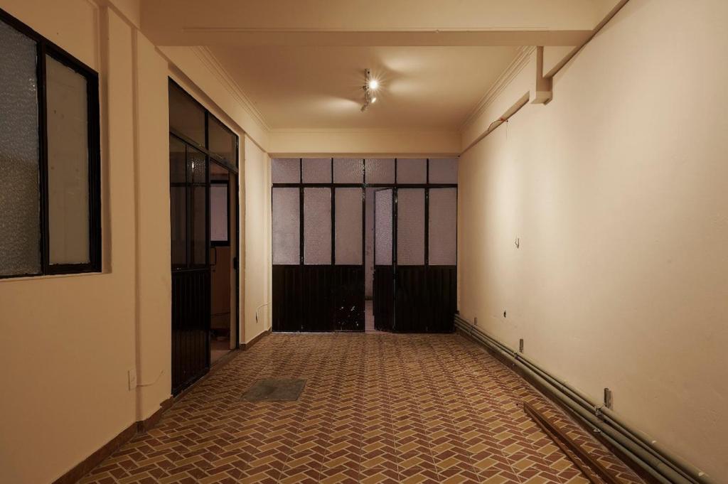 an empty hallway with a room with glass windows at Rojo Diseno Ubicacion Confort y AC in Oaxaca City