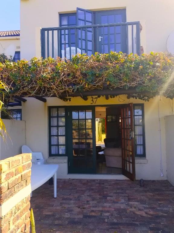 a house with a balcony with plants on it at Harmony On Kowie in Port Alfred