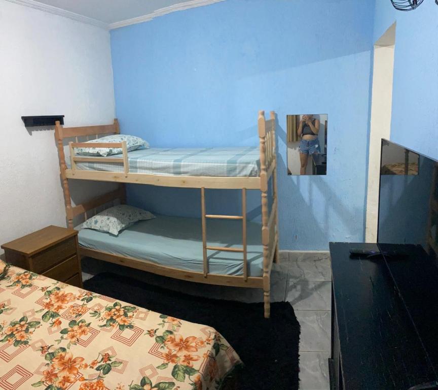 two bunk beds in a room with a blue wall at Recanto CostaCastilho in Bertioga
