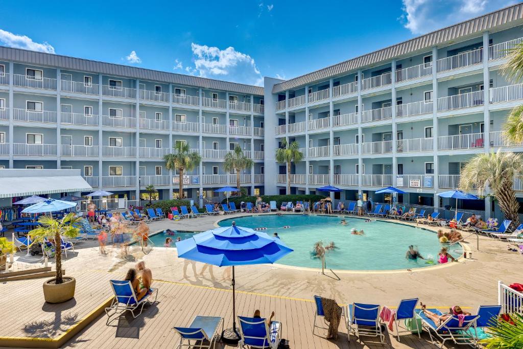 a hotel with a swimming pool with people in it at Wright by the Beach Hilton Head Condo with Perks in Hilton Head Island