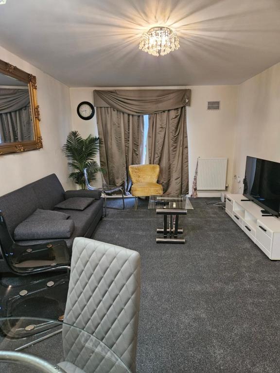 ミルトン・キーンズにあるLux Den close to M1! Netflix , Parking & Broadbandのソファとテレビのあるリビングルーム