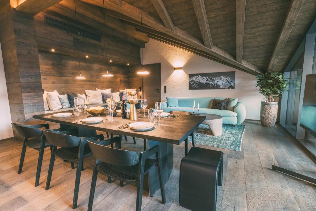 a dining room with a table and chairs and a couch at LIVALPIN Residence - with private Sauna & Whirlpool in Garmisch-Partenkirchen