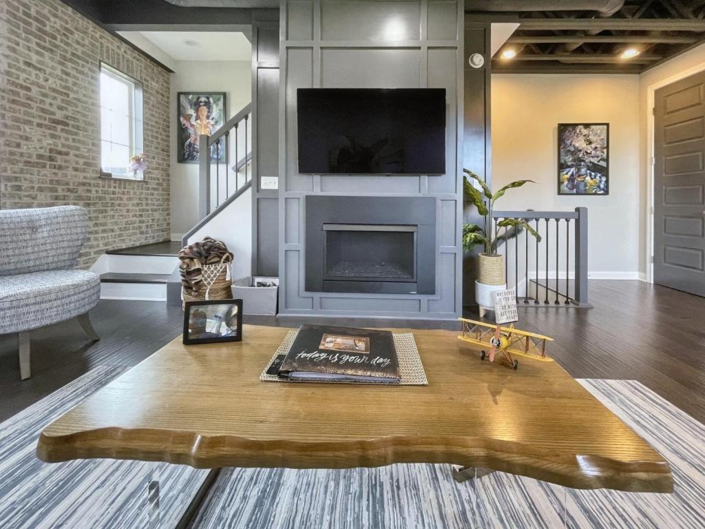 een woonkamer met een open haard en een houten salontafel bij Bird View at Parklake in Springboro
