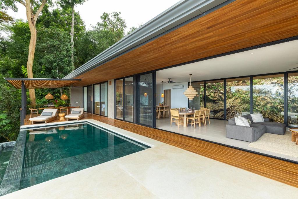 a house with a swimming pool and a living room at Casa Roca in Santa Teresa Beach