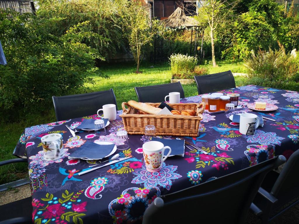 un tavolo da picnic con un cesto di cibo sopra di Chambre nature table d'hôte avec jardin à la campagne le nid qui danse vers Vesoul de 1 à 3 personnes a Baignes