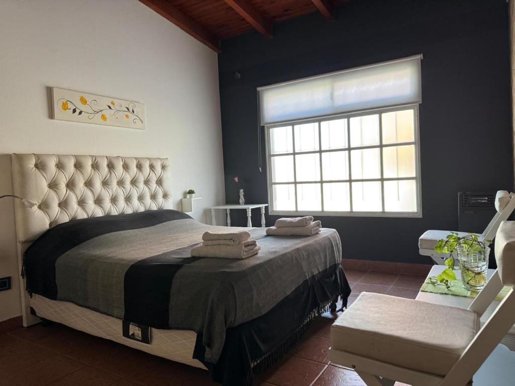 Un dormitorio con una cama y una silla y una ventana. en Alquiler por Día Alca!!!!, en Viedma