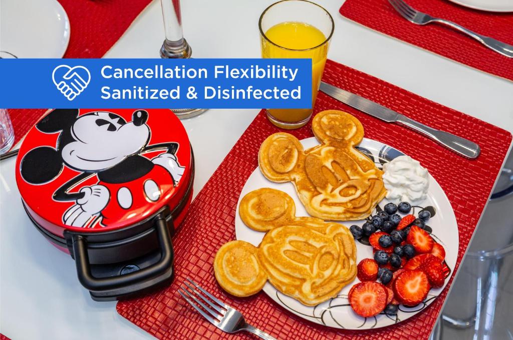 a plate of pancakes and fruit on a table at Mickey Mouse #104 in Orlando