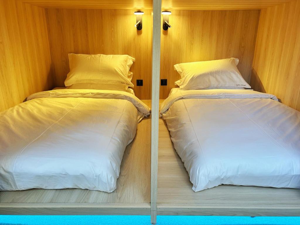 two beds sitting next to each other in a room at UNPLAN Hostel in Madrid