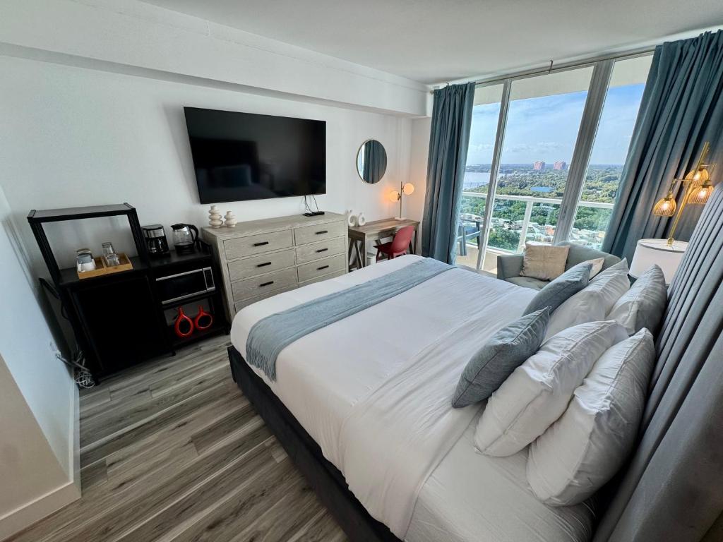 une chambre avec un grand lit avec une grande fenêtre dans l'établissement Balcony Ocean View ! Pool - WiFi - Gym - Parking, à Miami