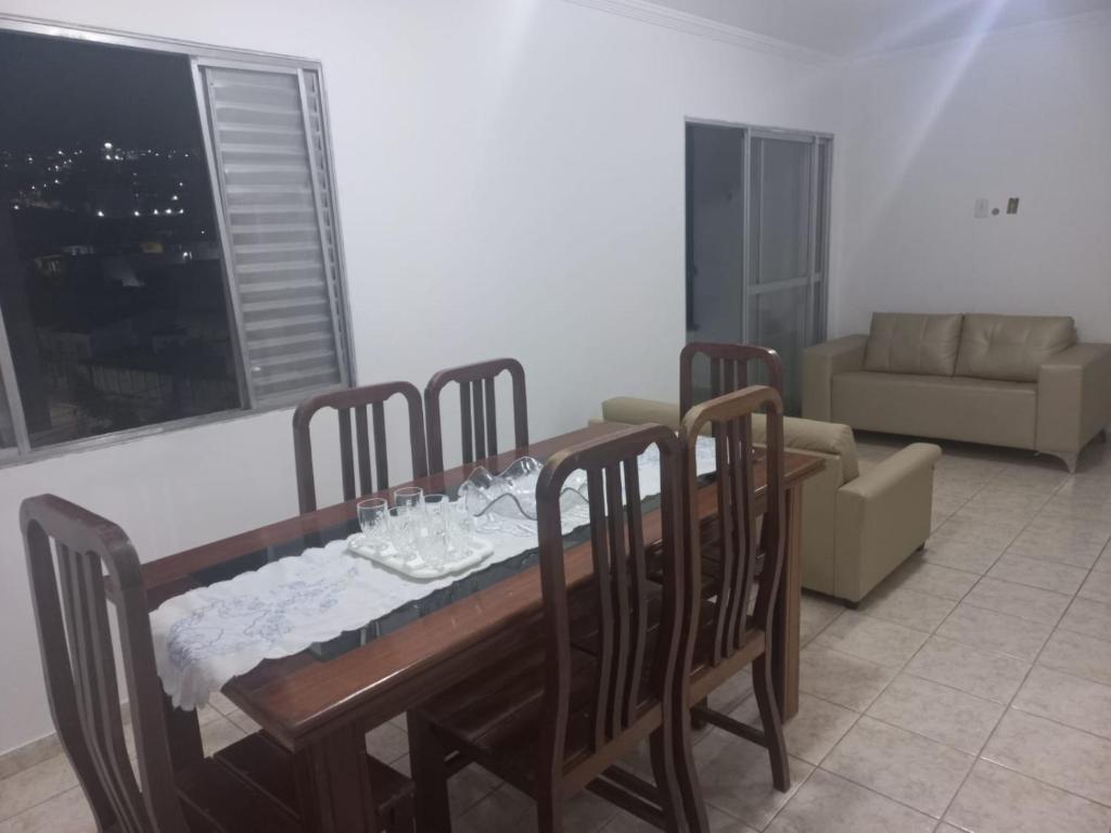 a dining room with a table and chairs and a couch at Apartamento para temporada Garanhuns in Garanhuns