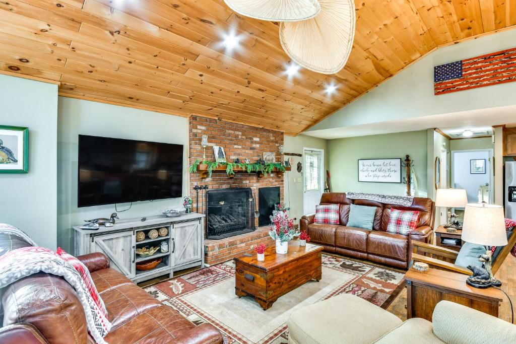 ein Wohnzimmer mit Kamin und Fernseher in der Unterkunft Riverfront Newland Home with Pool and Golf Club Access in Newland