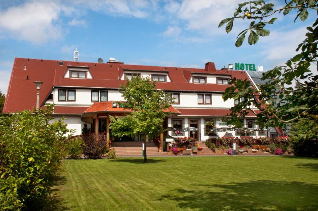 a hotel with a green lawn in front of it at Waldhotel Rennsteighof in Bad Liebenstein